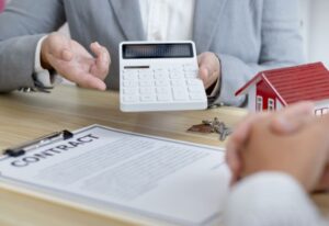 contrat sur table avec calculette et clef de maison