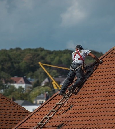 homme grimpant sur un toit avec un harnais