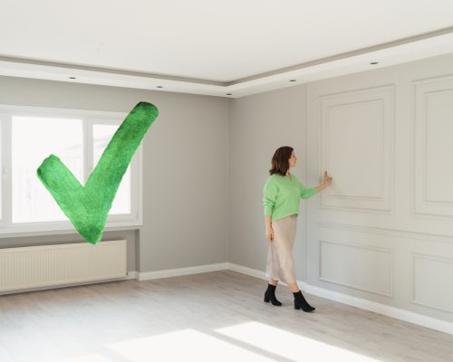 femme qui touche le mur d'un appartement avec logo "check"