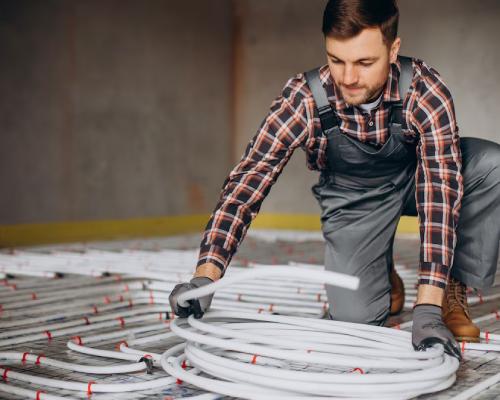 homme travaillant avec des tuyaux de chauffage