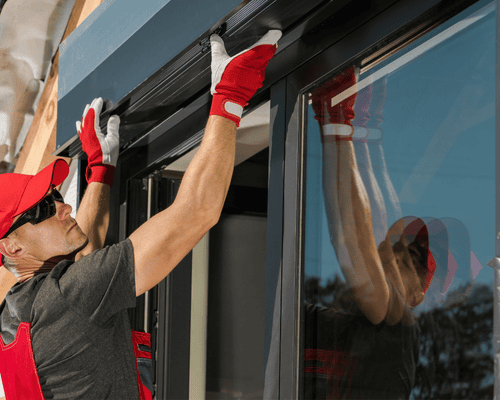 professionnel en train d 'installer des volets roulants sur des fenêtres