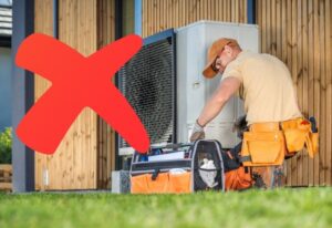 ouvrier qui installe une pompe à chaleur avec une croix rouge