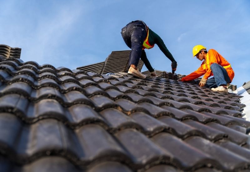 deux hommes qui travaillent sur un toit