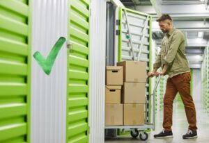 homme qui stock des cartons dans un box